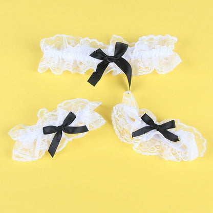 Three white lace garters with black bows on a yellow background