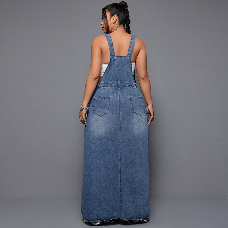 Woman wearing a long denim dress against a gray background