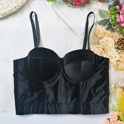 Black satin bralette on a decorative background with flowers and greenery