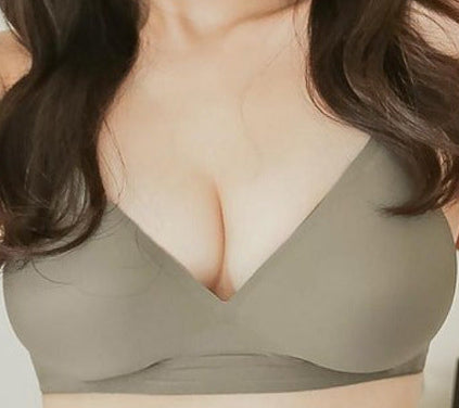 Woman wearing a green bra in a well-lit room.