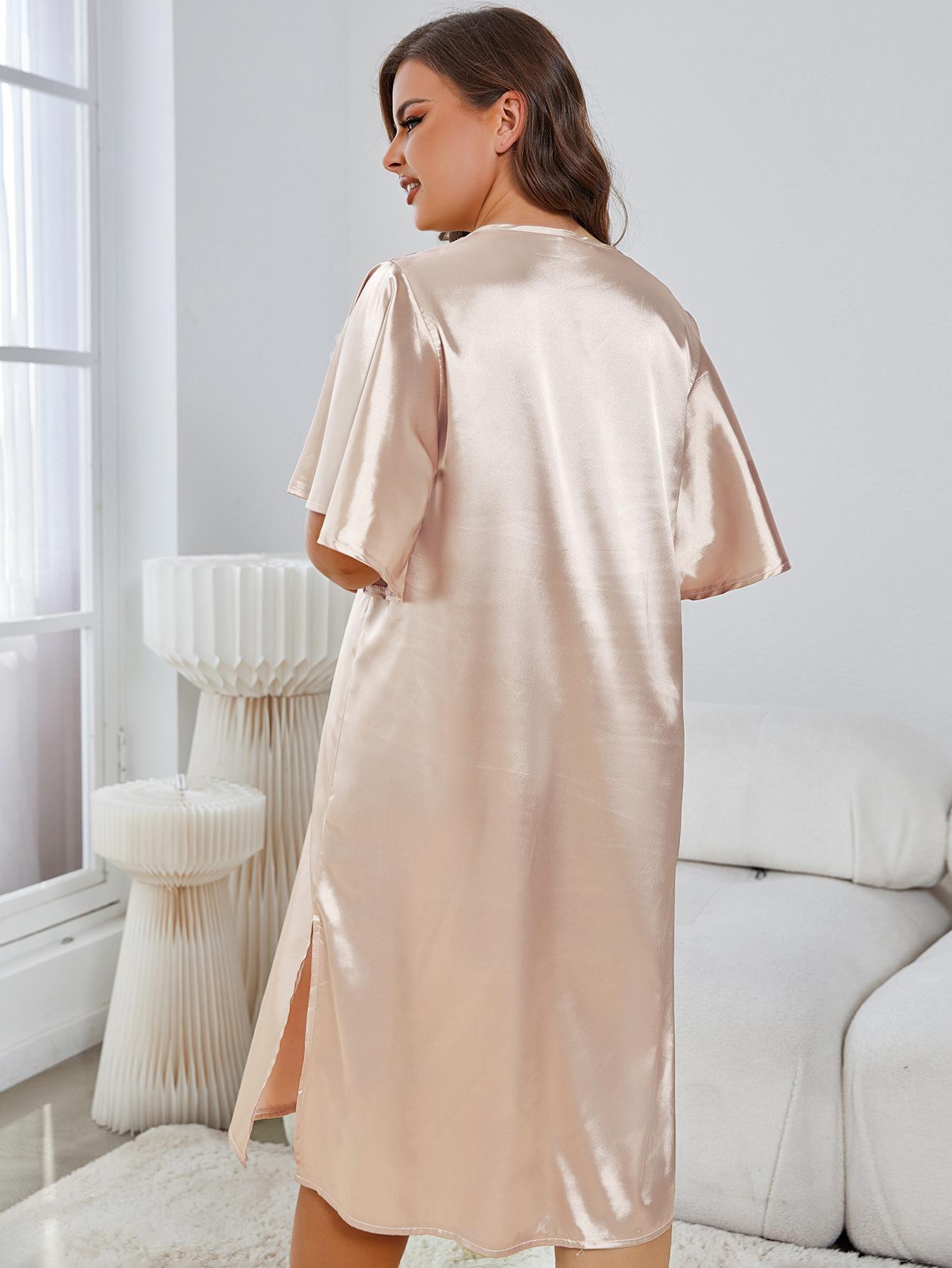 Woman wearing a beige satin robe in a modern living room.