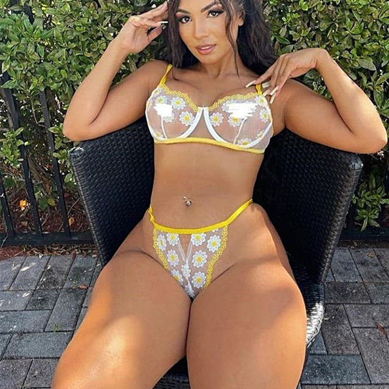 Woman wearing a yellow and white floral bikini sitting outdoors.