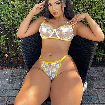 Woman wearing a yellow and white floral bikini sitting outdoors.
