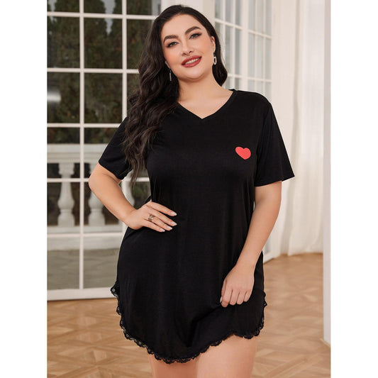 Woman wearing a black nightshirt with a red heart design indoors.