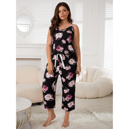 Woman wearing a black floral jumpsuit in a bright living room.