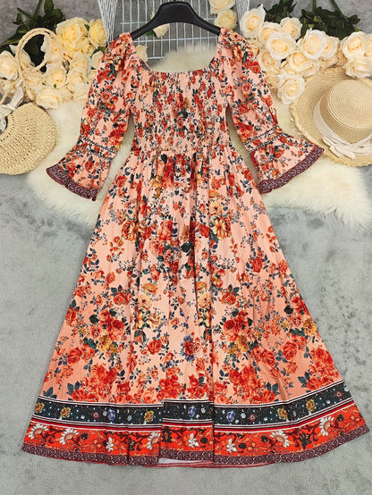 Floral dress with bell sleeves on a textured surface with decorative items.