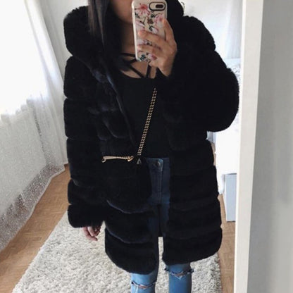 Person wearing a black fur coat taking a mirror selfie.