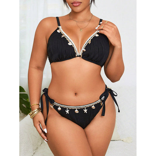 Black bikini with decorative details worn by a model on a white background
