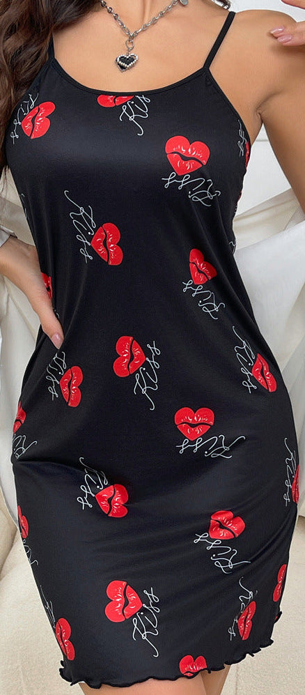 Woman wearing a black slip dress with red heart patterns in a living room setting.