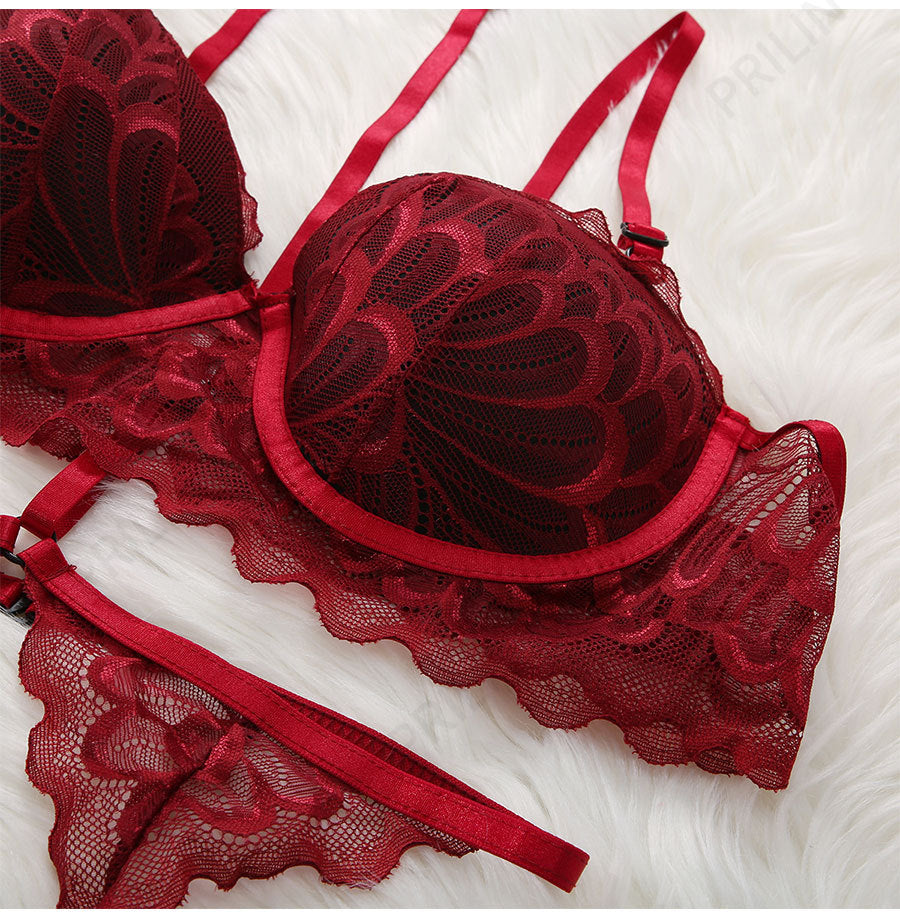 Red lace lingerie set on a white textured surface