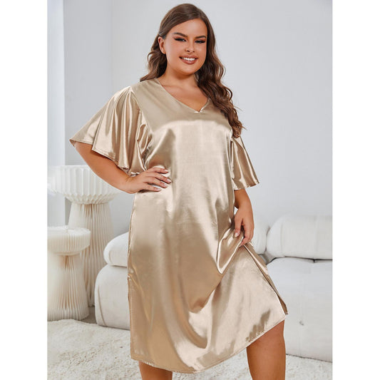 Woman wearing a gold satin nightgown in a cozy room.