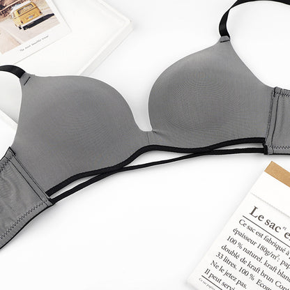 Gray bra with black straps on a white surface
