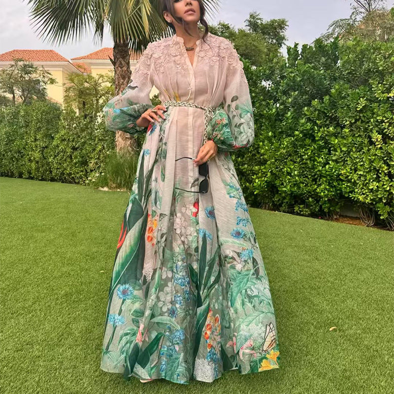 Woman in a floral dress standing on grass with greenery in the background
