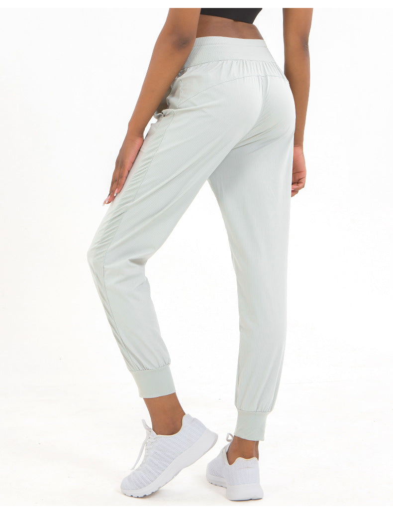 White jogger pants worn by a person on a white background